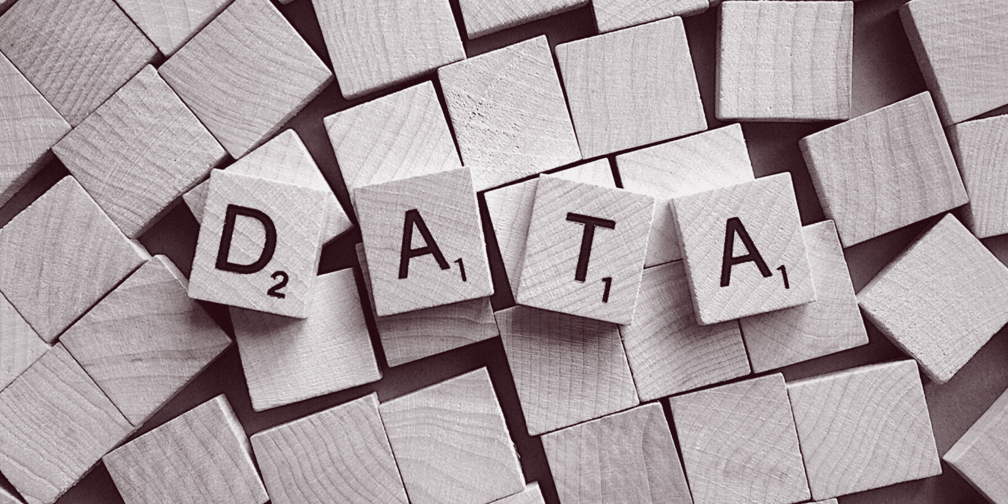 Holzwürfel. Auf vier Würfeln stehen Buchstaben die das Wort DATA bilden.